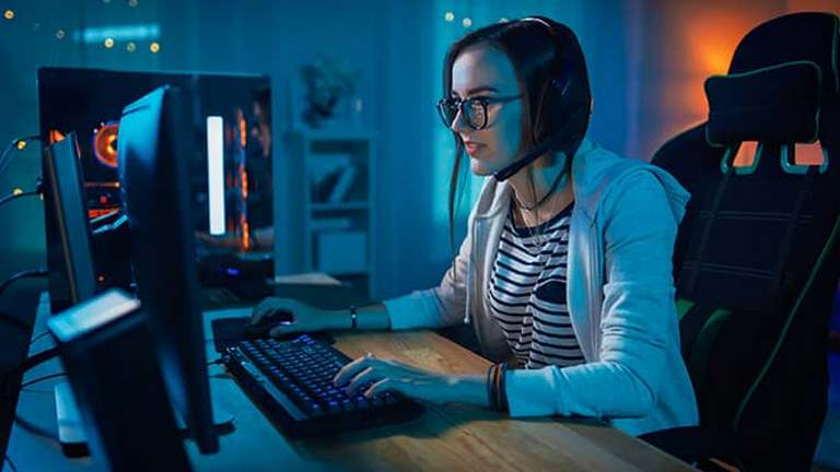 کامپیوتر بهتر است یا کنسول بازی دختر گیمر عینکی مشغول بازی با کامپیوتر